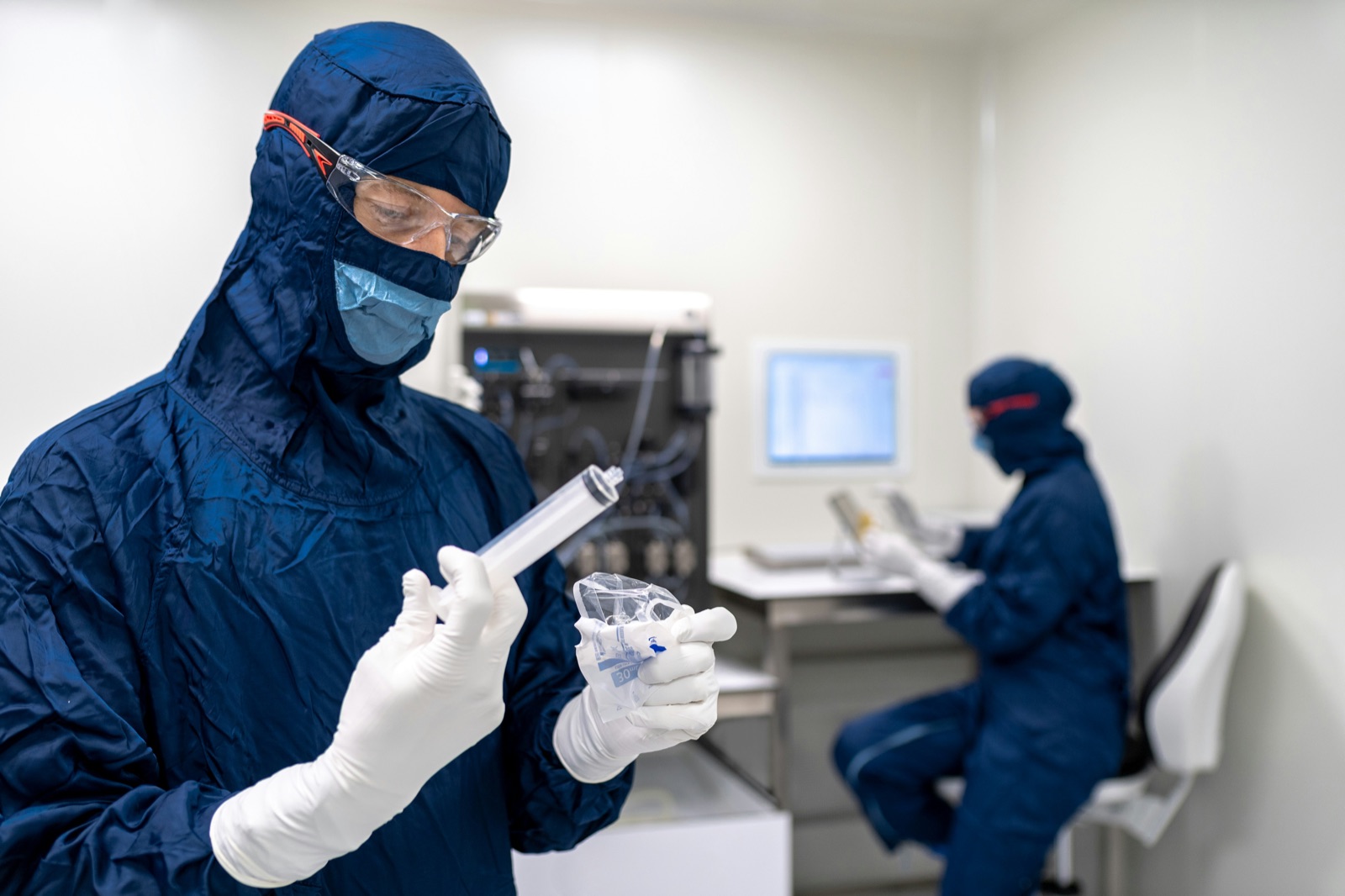 Cleanroom workers in protective gear for Incure CDM™ UV conveyor medical device bonding production