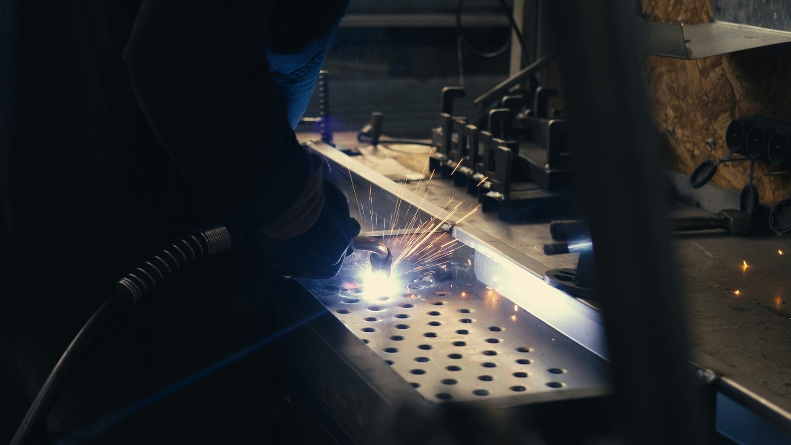 Welder repairing metal components with sparks for industrial maintenance using Epo-Weld™ HTCP high temperature putty