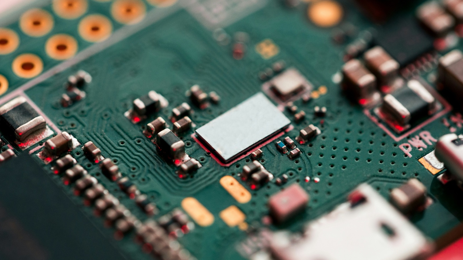 Macro of green circuit board with metal-shielded module for Epo-Weld™ UHB ultra high bond epoxy deep pour potting