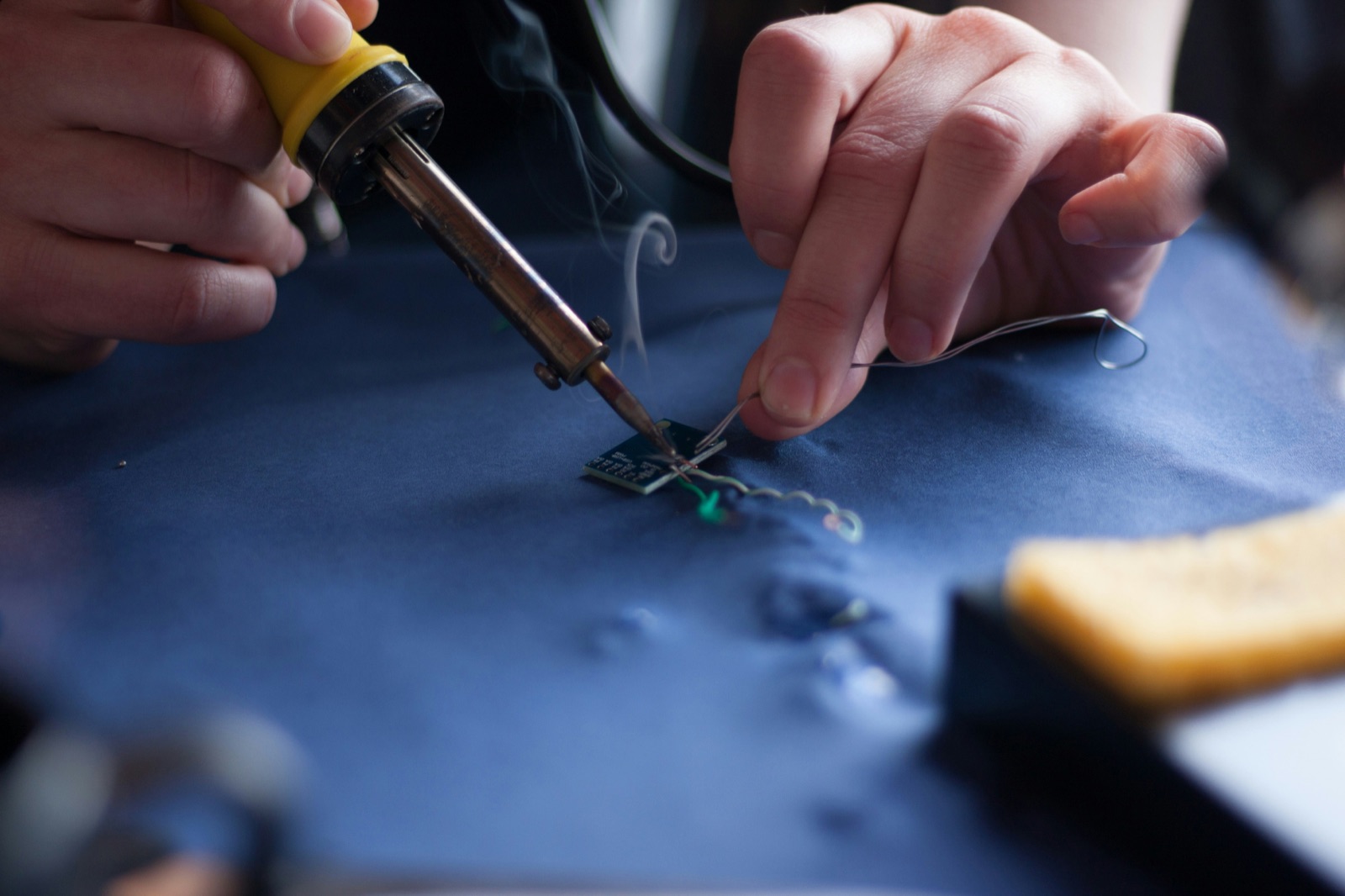 Person using soldering iron on electronic assembly for Epo-Weld™ UHB ultra high bond epoxy electronic assembly