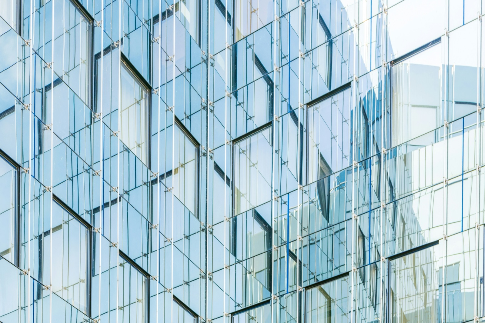 Architectural glass facade with reflective blue panels for structural glass bonding applications