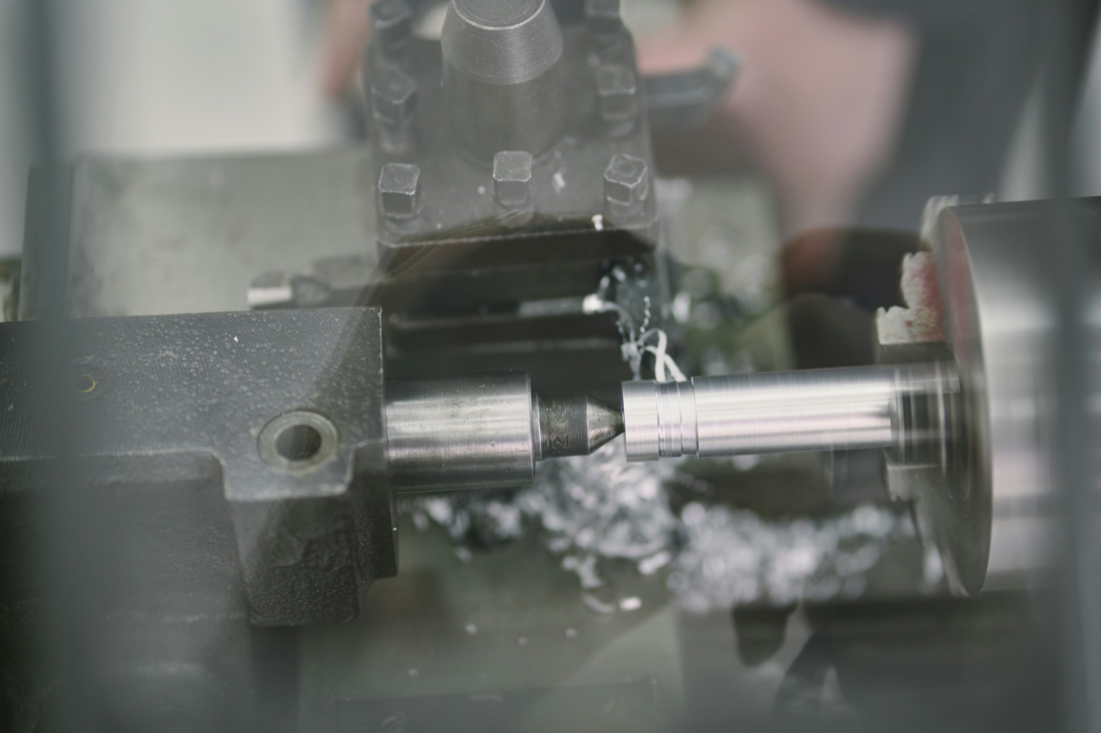Metal lathe turning cylindrical rod in industrial workshop for Pyra-Sil™ machining and sandblasting masking