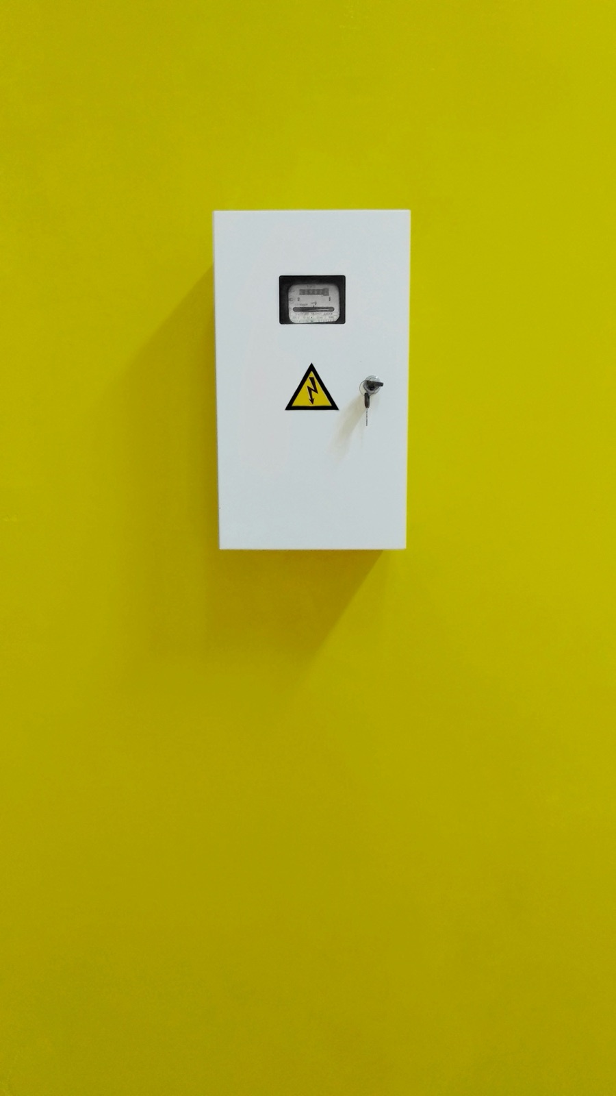 White electrical enclosure on a yellow wall for Pyra-Sil™ RTV silicone electrical enclosure weatherproof IP sealing