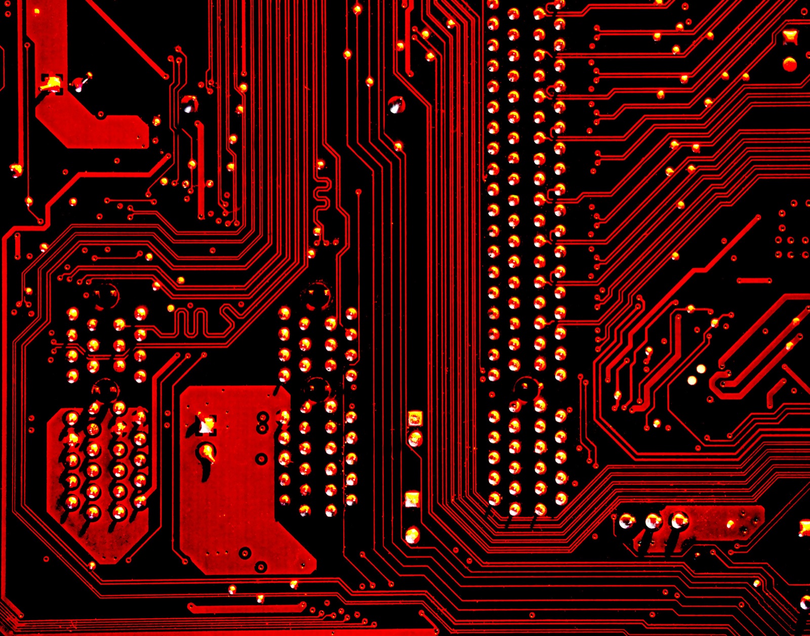 Red-lit macro circuit board showing PCB trace and pad patterns for Ultra-Illumina™ UV conformal coating micro-crack