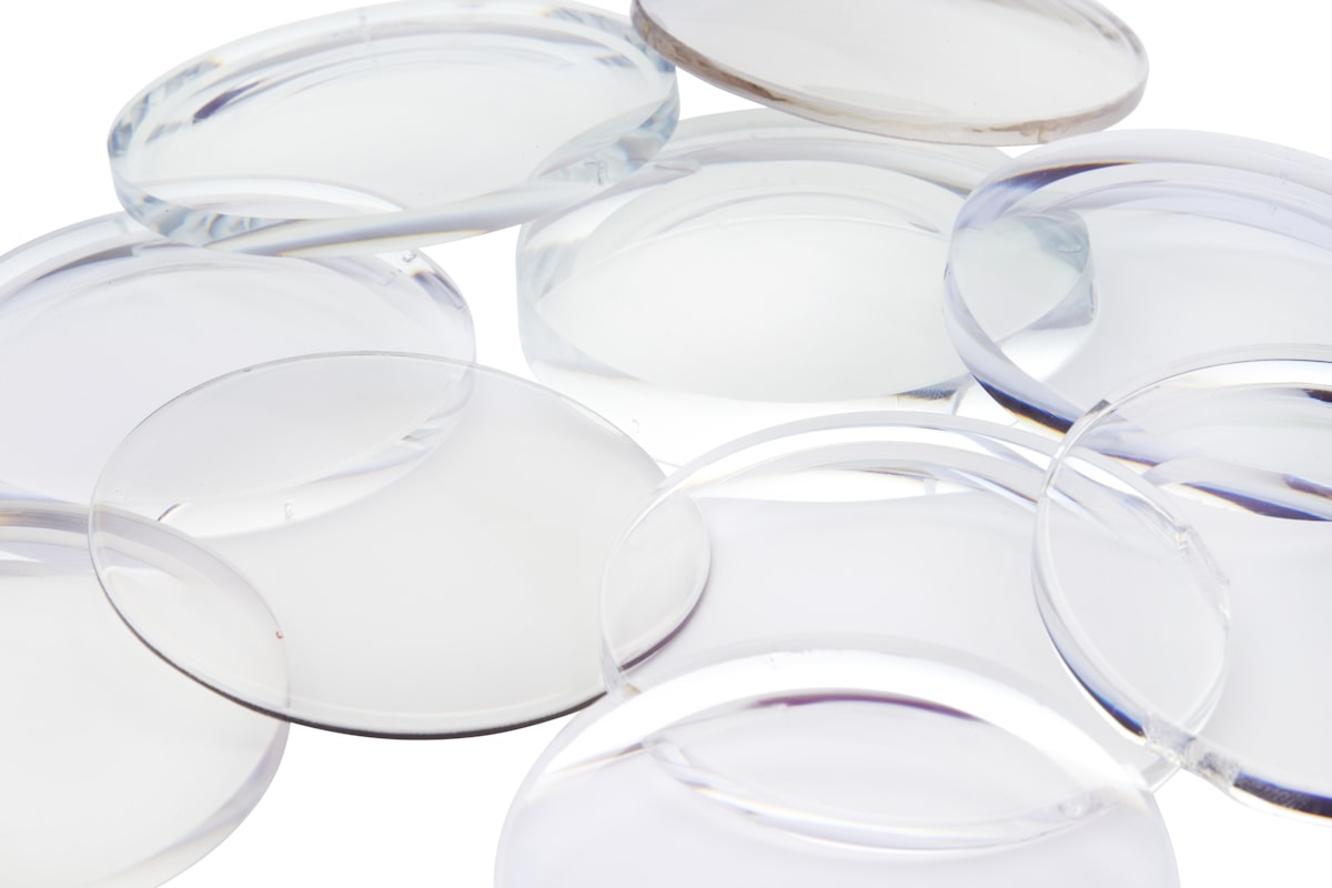 Multiple clear optical lens blanks on white surface for Cast-Max™ UV lens casting and light guide encapsulation