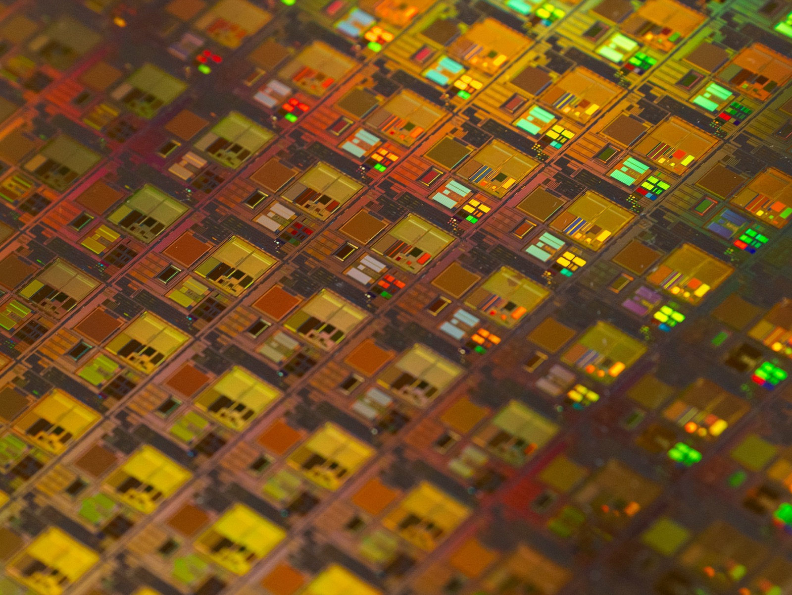 Iridescent semiconductor wafer surface showing die patterns for Incure M-Series™ UV focused beam electronics assembly
