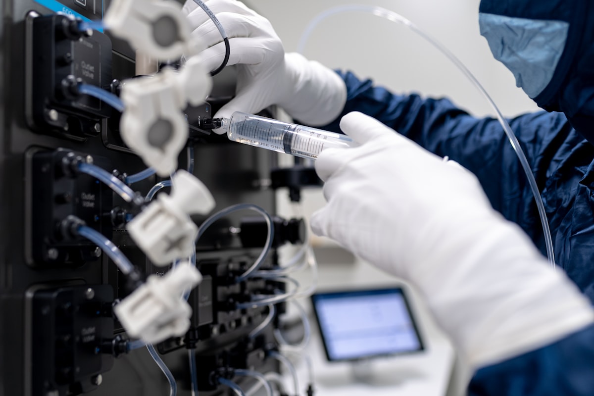 Lab technician in white coat at computer for Litemask™ UV maskant use during medical device passivation