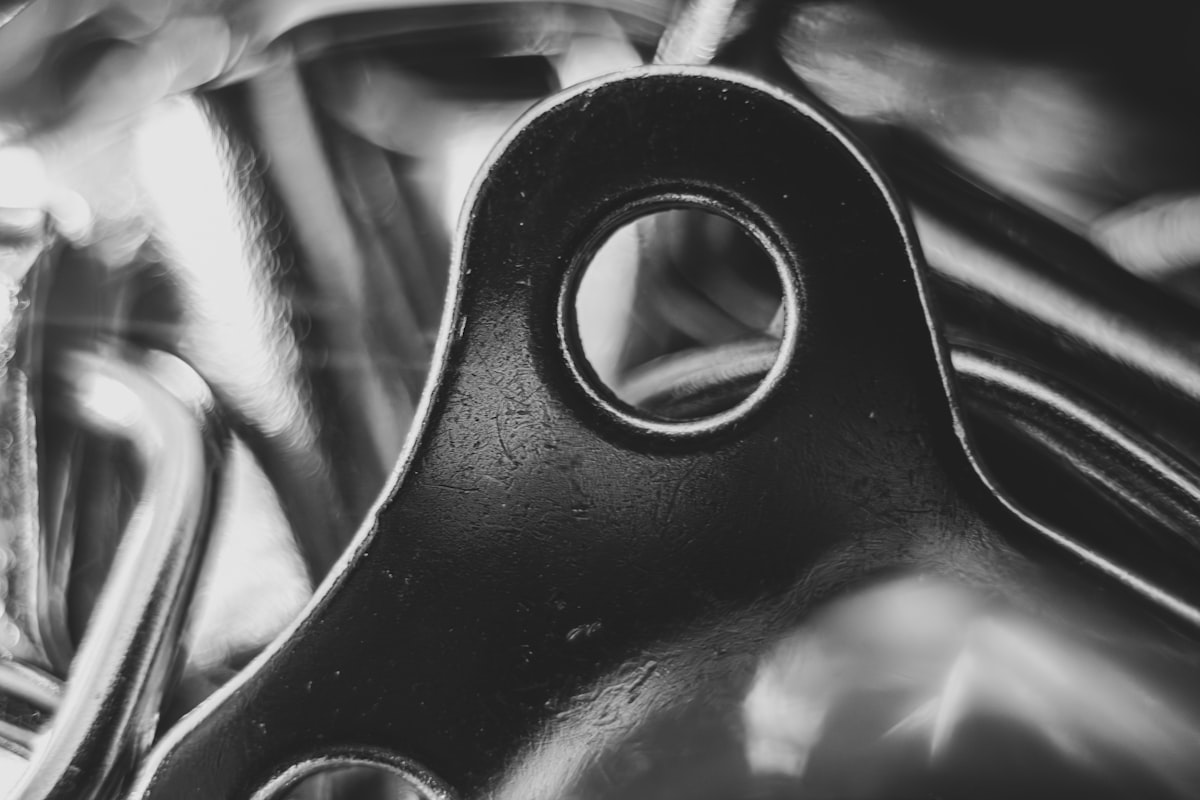 Polished shiny metal bracket with precision hole for Litemask™ UV maskant surface protection during anodizing